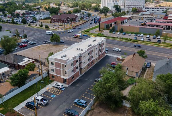 newly built multifamily housing complex in an urban neighborhood, illustrating efficient site planning, tenant parking, and modern construction for real estate investors and developers.