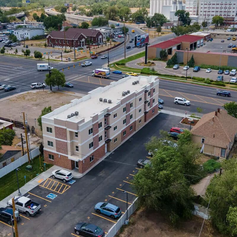 newly built multifamily housing complex in an urban neighborhood, illustrating efficient site planning, tenant parking, and modern construction for real estate investors and developers.