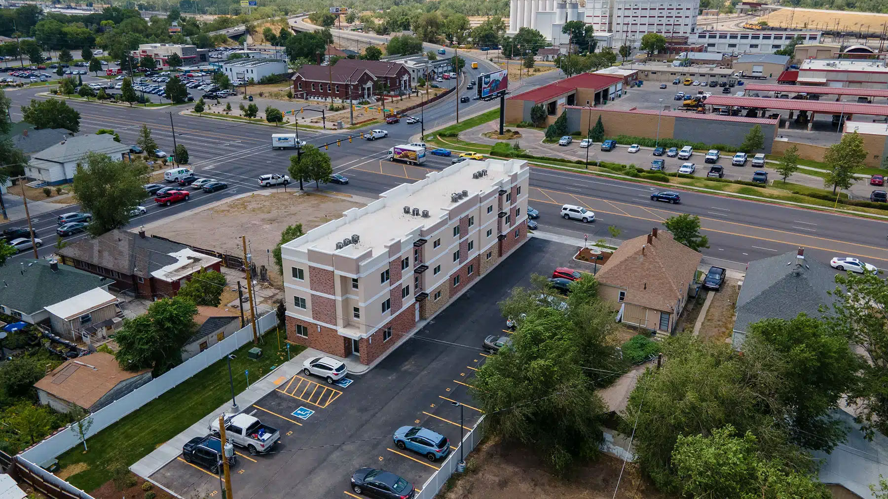 newly built multifamily housing complex in an urban neighborhood, illustrating efficient site planning, tenant parking, and modern construction for real estate investors and developers.