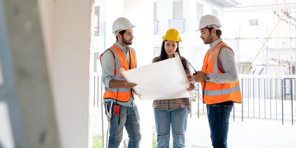 Tenant improvement contractors review commercial construction plans for remodeling project