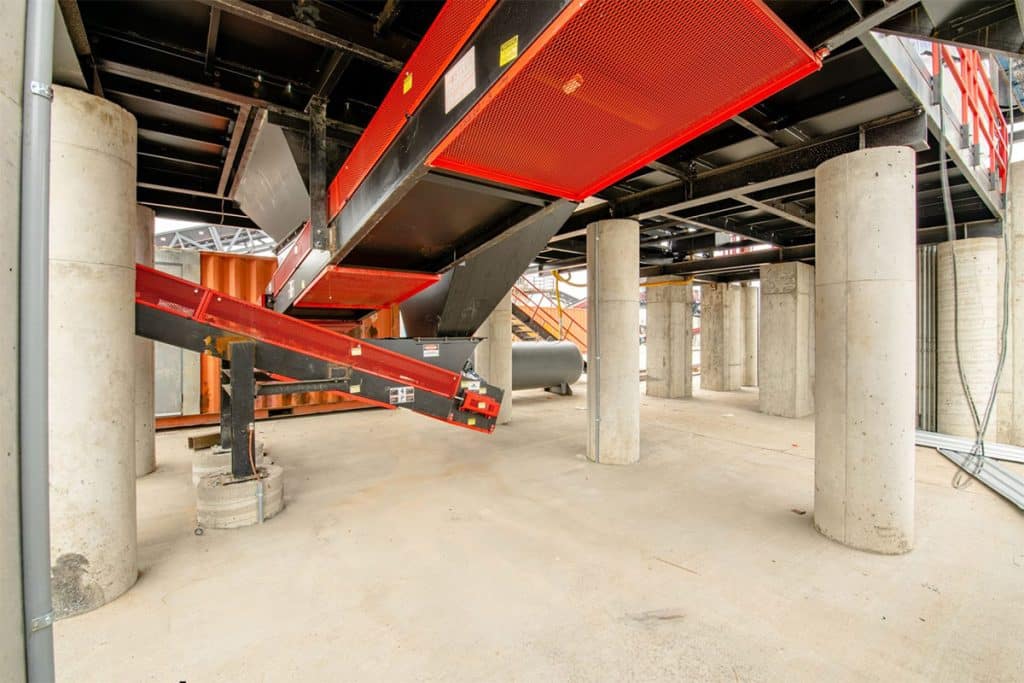 Metro Recycling's processing plant under construction, featuring conveyor systems, concrete columns, and supports.