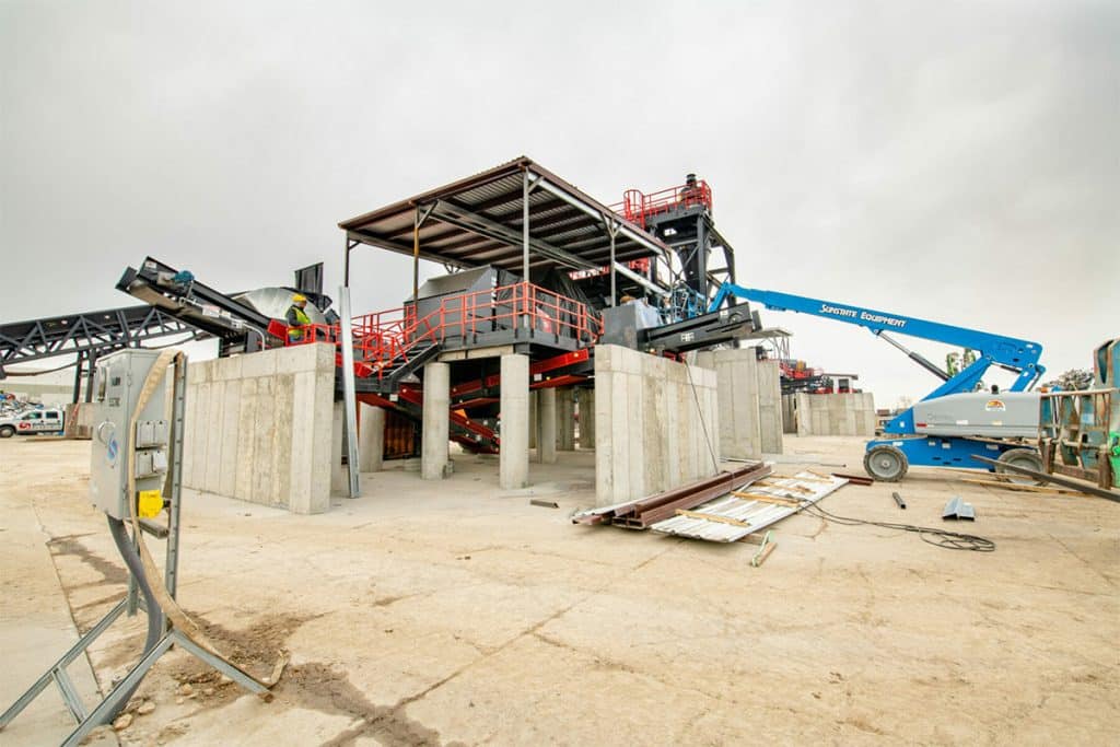 Cook Builders constructing Metro Recycling's processing plant with conveyors, concrete supports, and equipment.