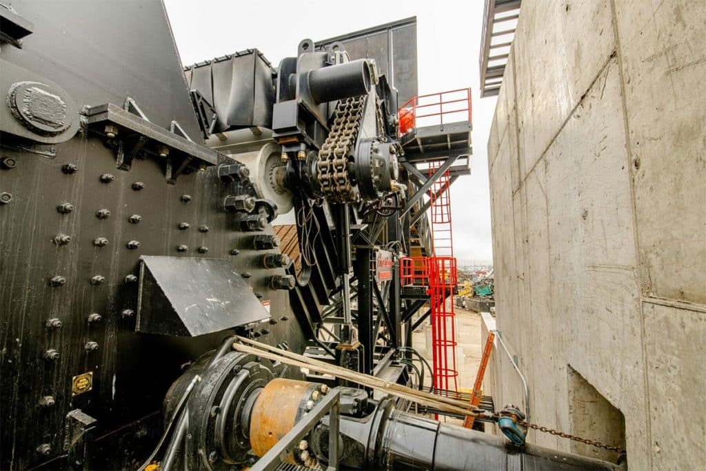 Close-up of heavy-duty machinery at Metro Recycling, featuring hydraulic components, large bolts, and chain systems.