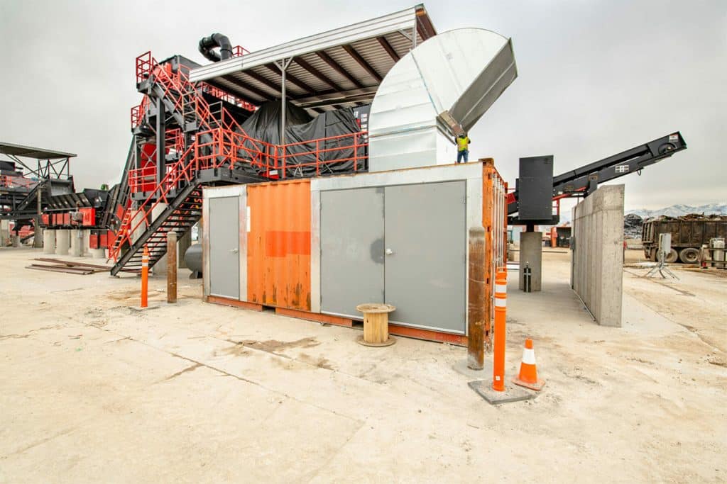 Metro Recycling's processing plant with staircases, conveyors, ventilation ducts, and a modified shipping container.
